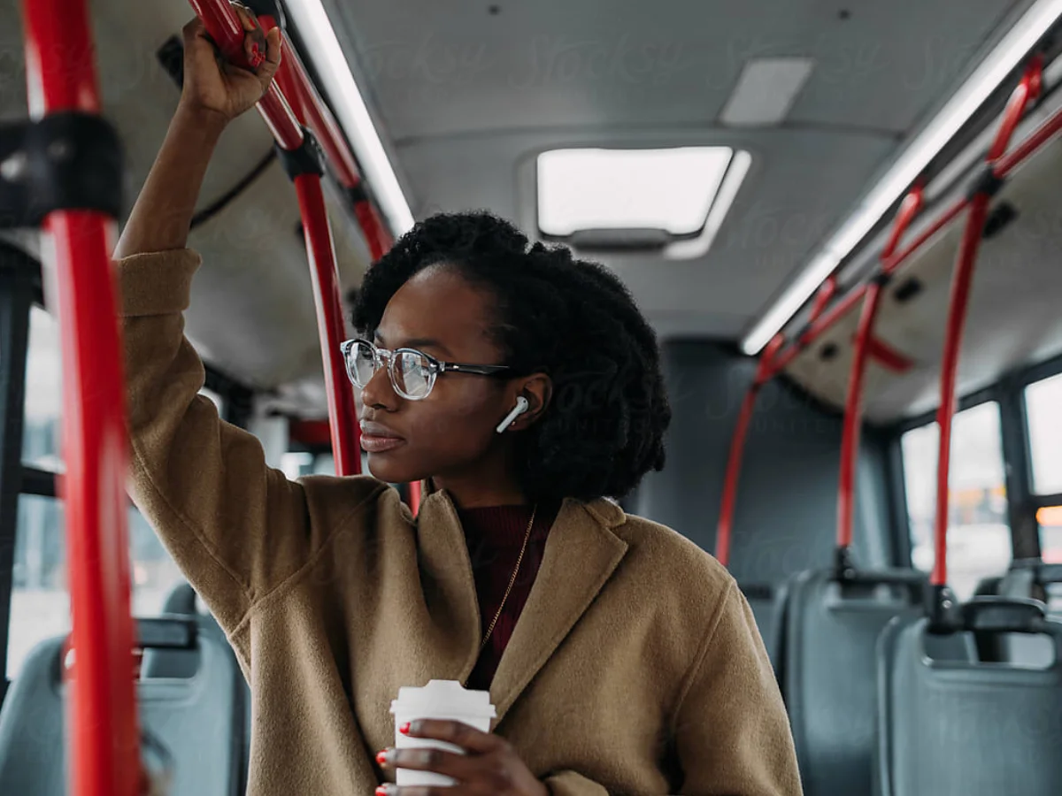 Girl with earphones looking off tram