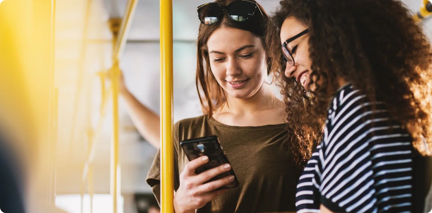 Girls looking at phone on train