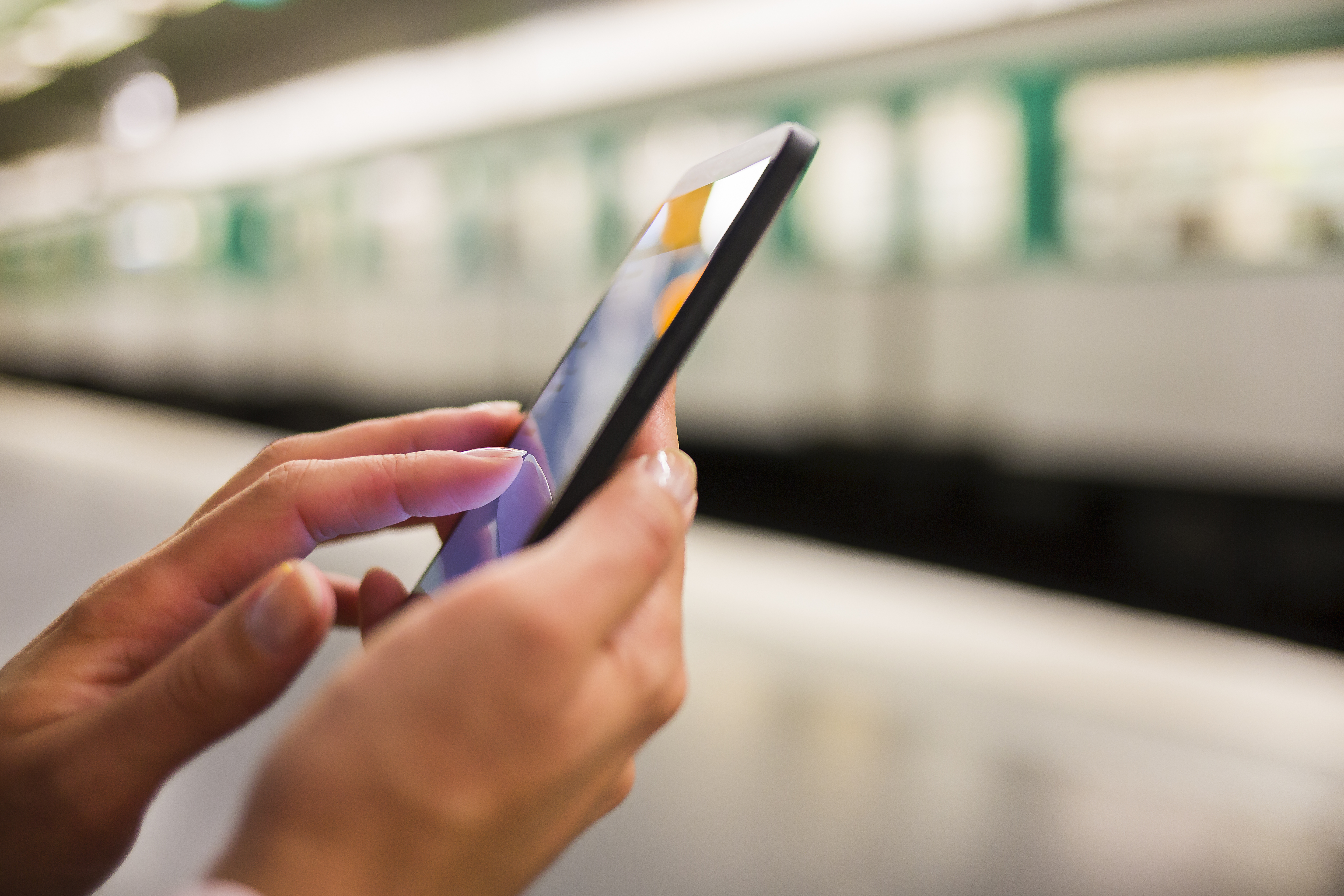 Mobile phone being used on a light rail platform