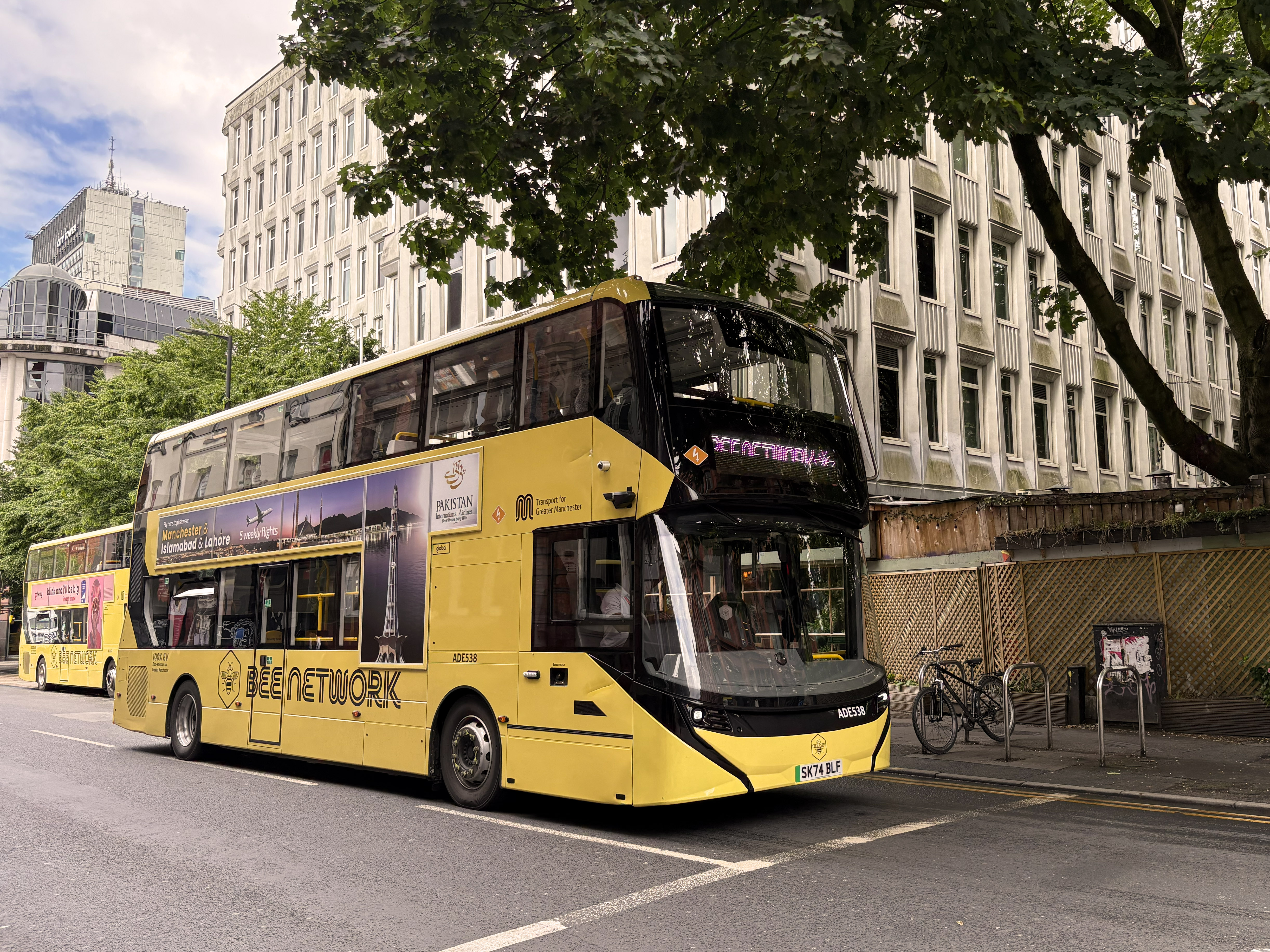 A Manchester bus driving down a street.